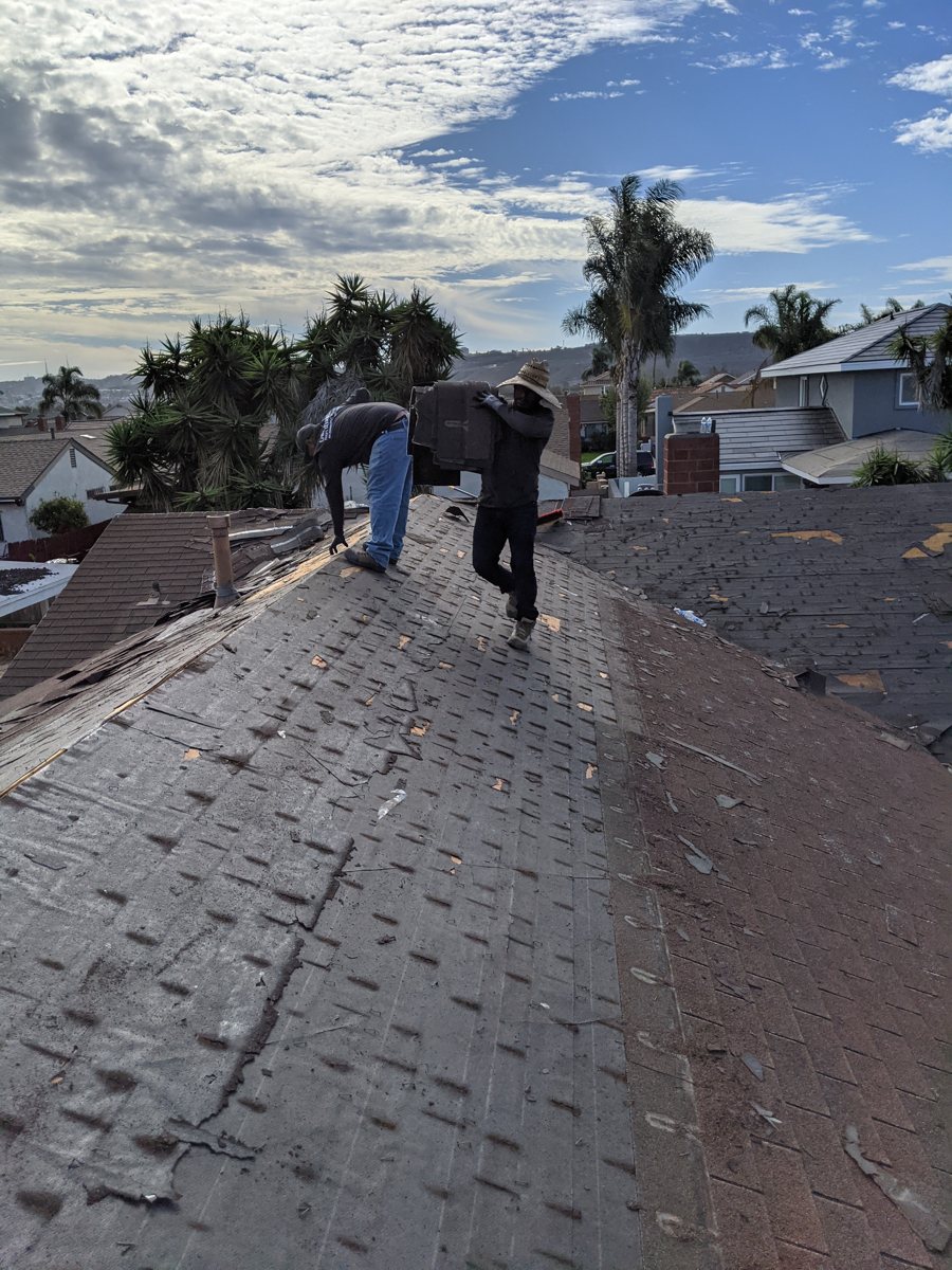 Guardian Roofs crew removing old shingles during a San Diego roof replacement